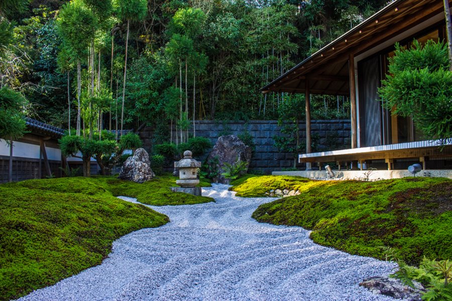 Tsukubai stone water basin with bamboo spout in Japanese zen garden